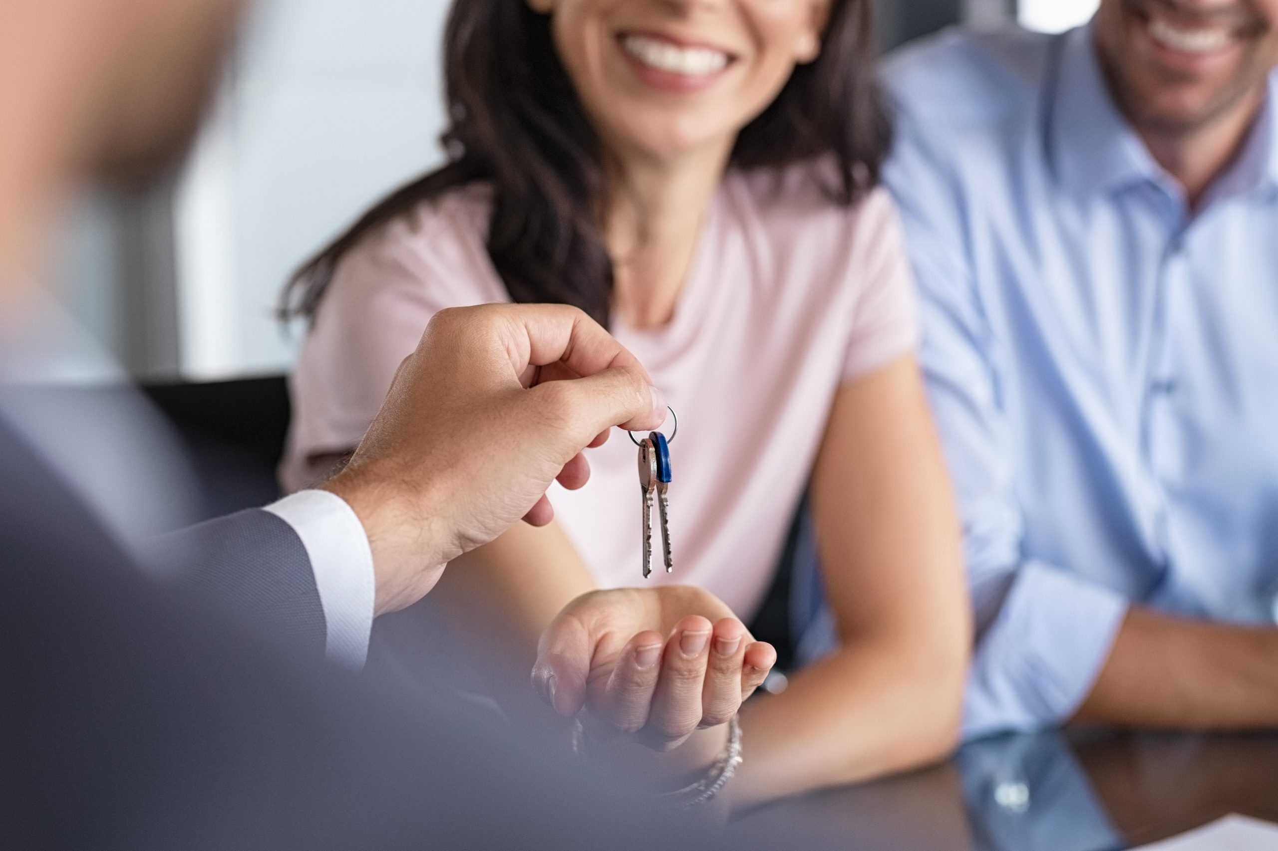 real-estate-agent-giving-house-keys-to-woman-UW7TA2X-min